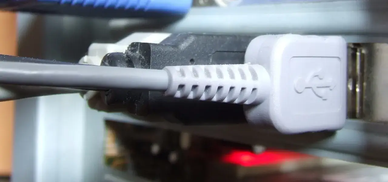 Szary kabel USB podłączony do portu. To jest interfejs, który pozwala na komunikację urządzeń.
